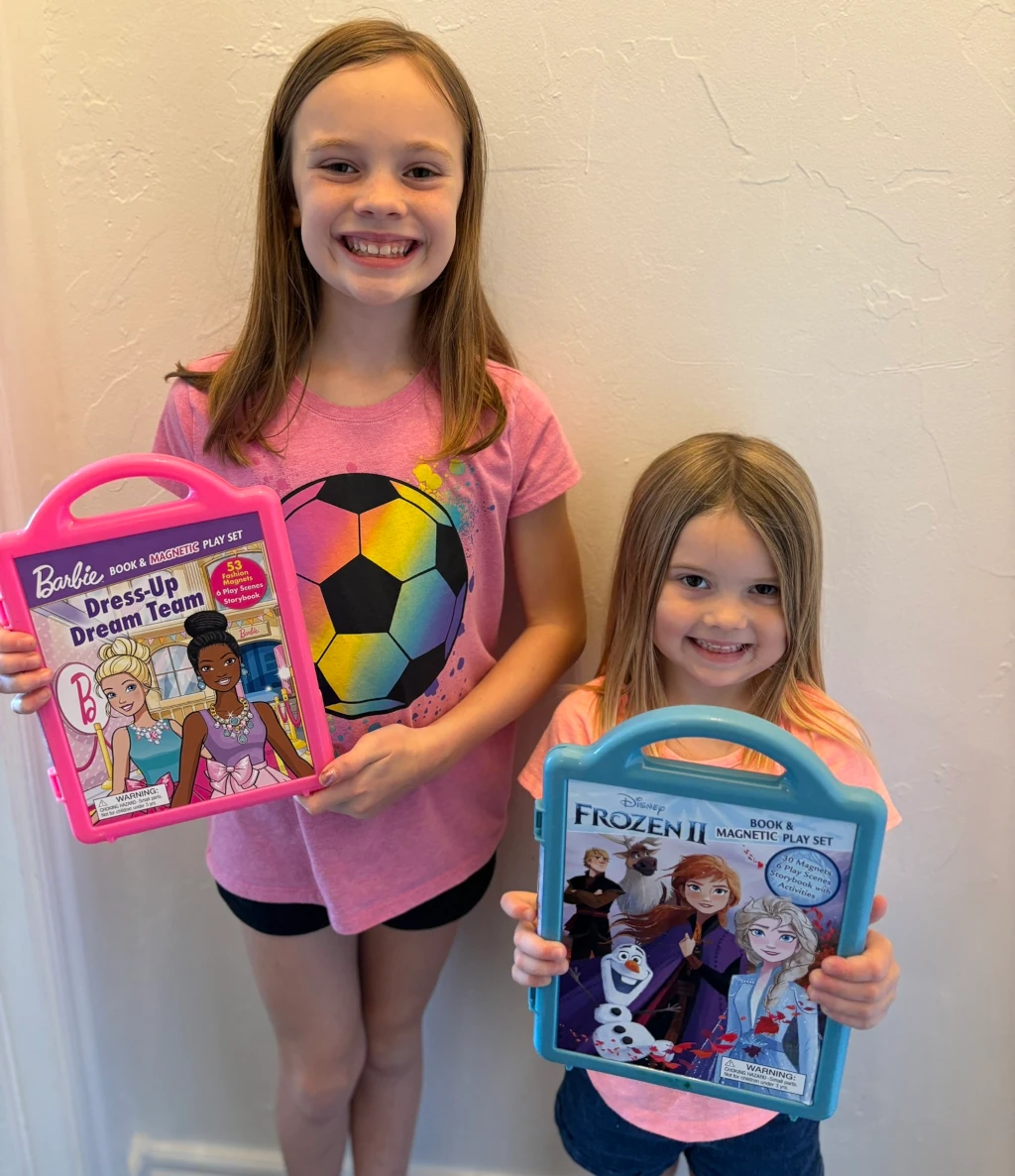 Two girls holding magnetic playsets