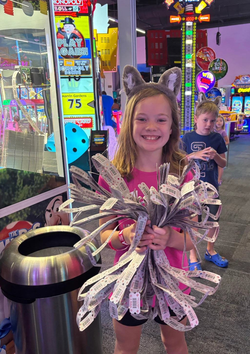 A girl holding arcade tickets