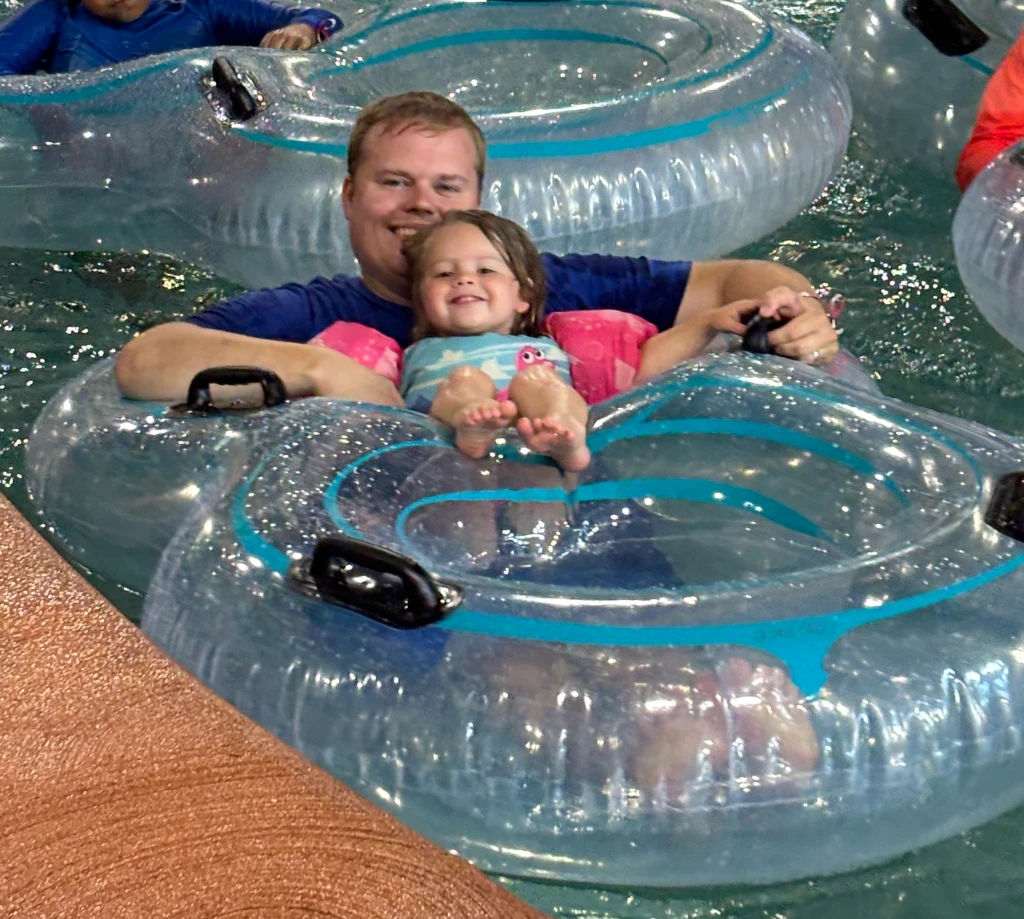 A dad and his daughter in a tube
