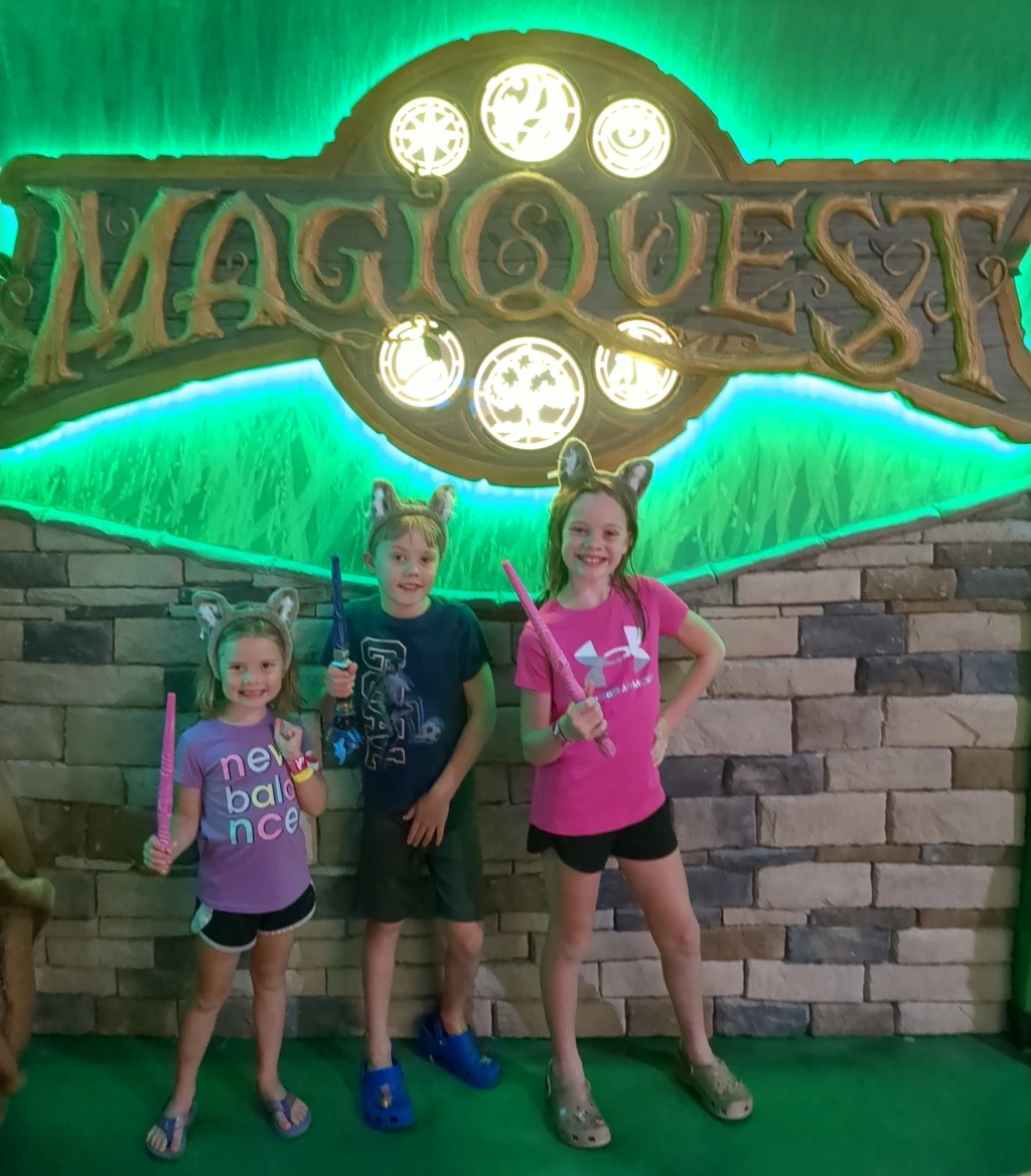 Kids posing by a MagiQuest sign
