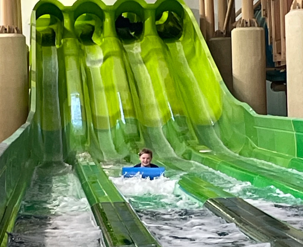 A boy riding a water slide