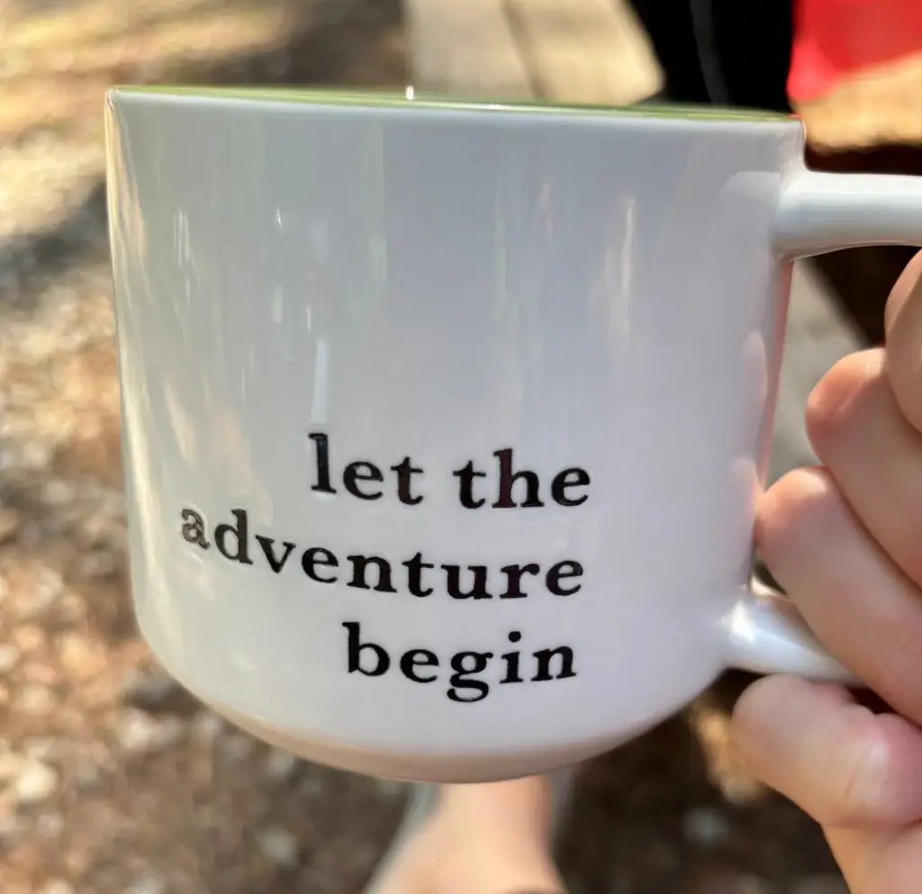 A mug that says 'Let the adventure begin'