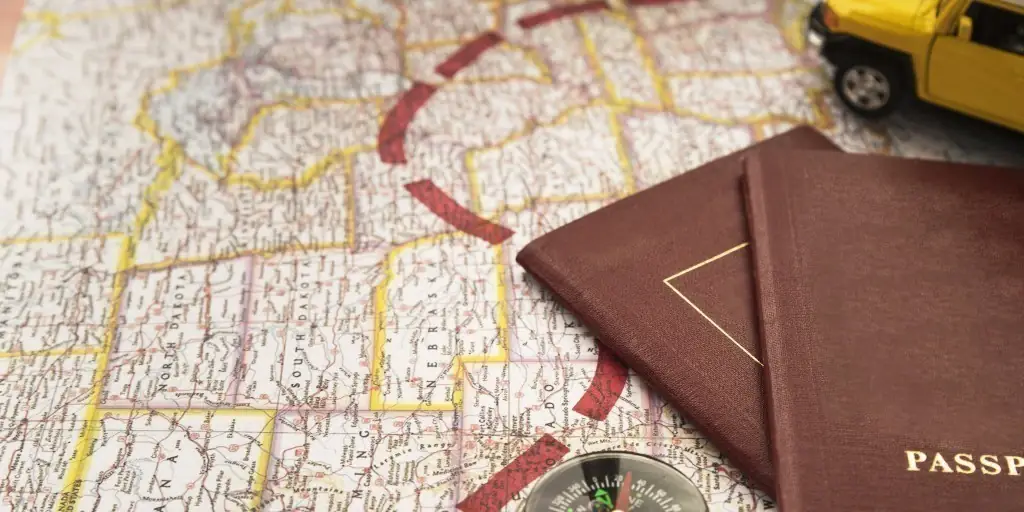 A map with a route plotted, a toy car, and a couple of passports