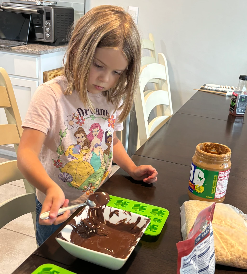 A girl pouring chocolate into a mold