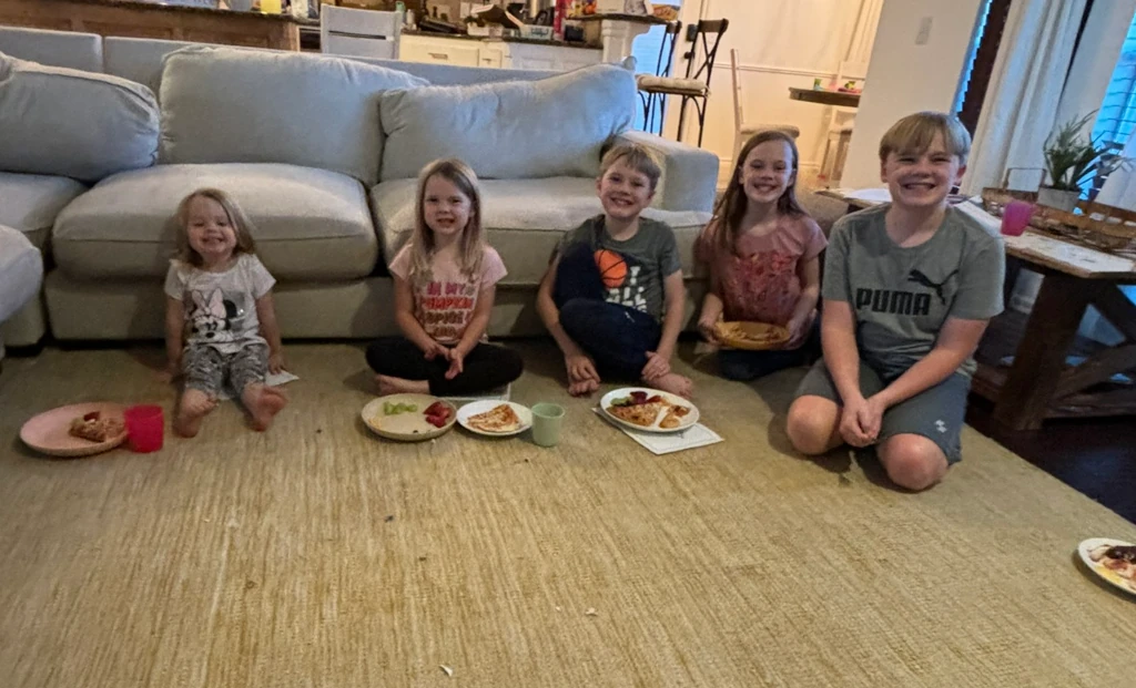 Kids waiting by a couch to watch a movie