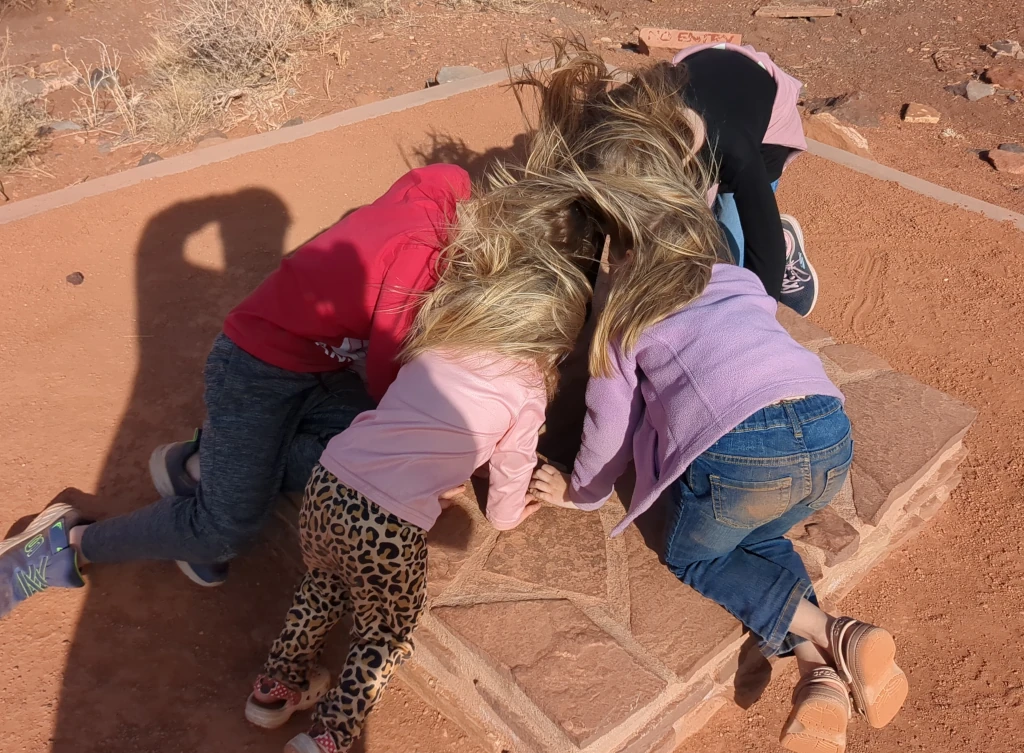 Kids with their hair blowing up from a geological blowhole