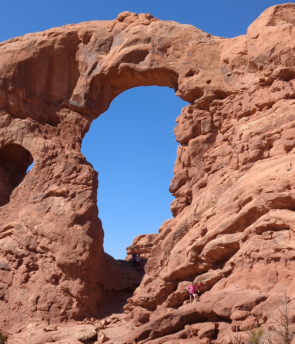 Kids posing below a natural stone arch