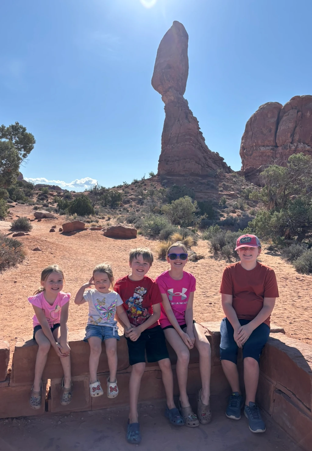 Kids posing in front of a rock formation