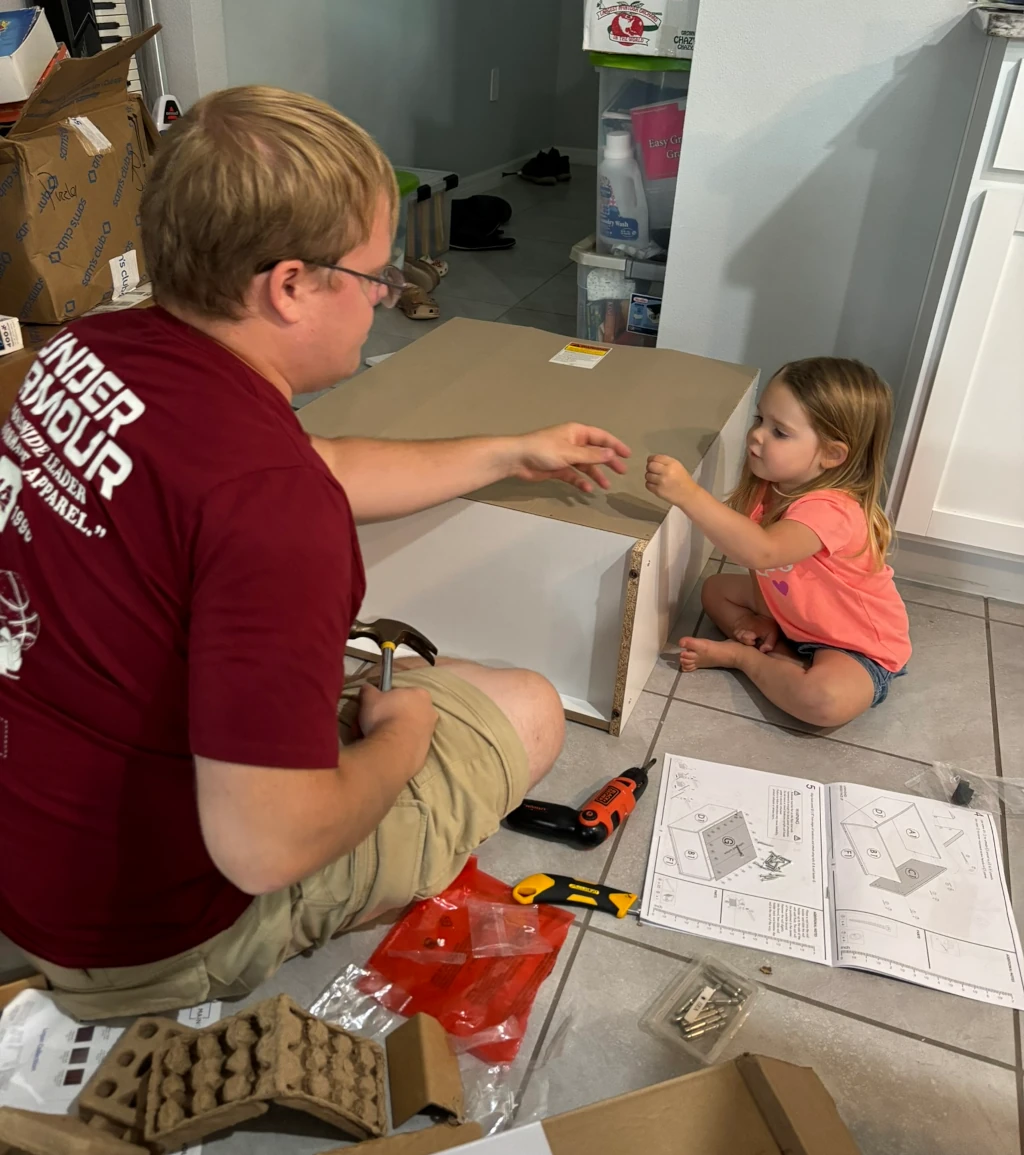 A dad building furniture with his daughter