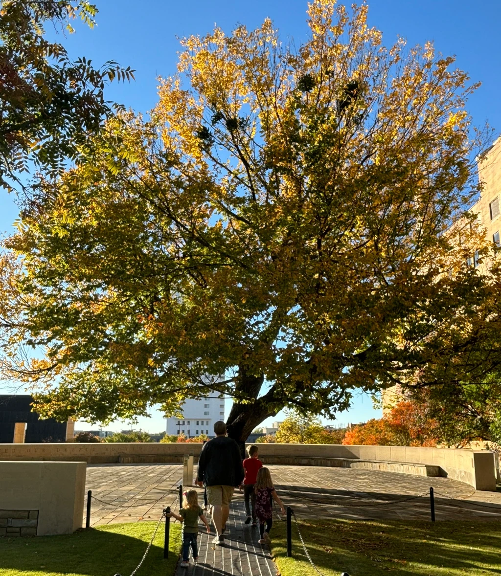 Some kids and their dad walking up to the Survivor Tree at the OKC National Memorial