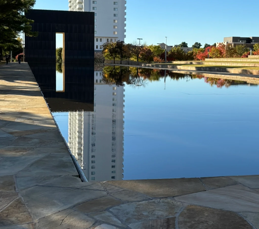 The Oklahoma City National Memorial's outside area with a water feature and a gate in the distance