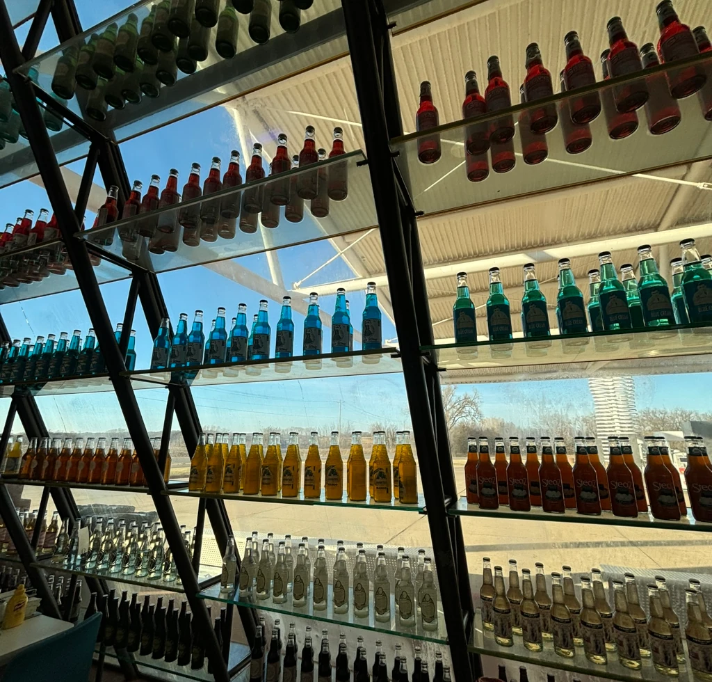 A wall covered in soda bottles