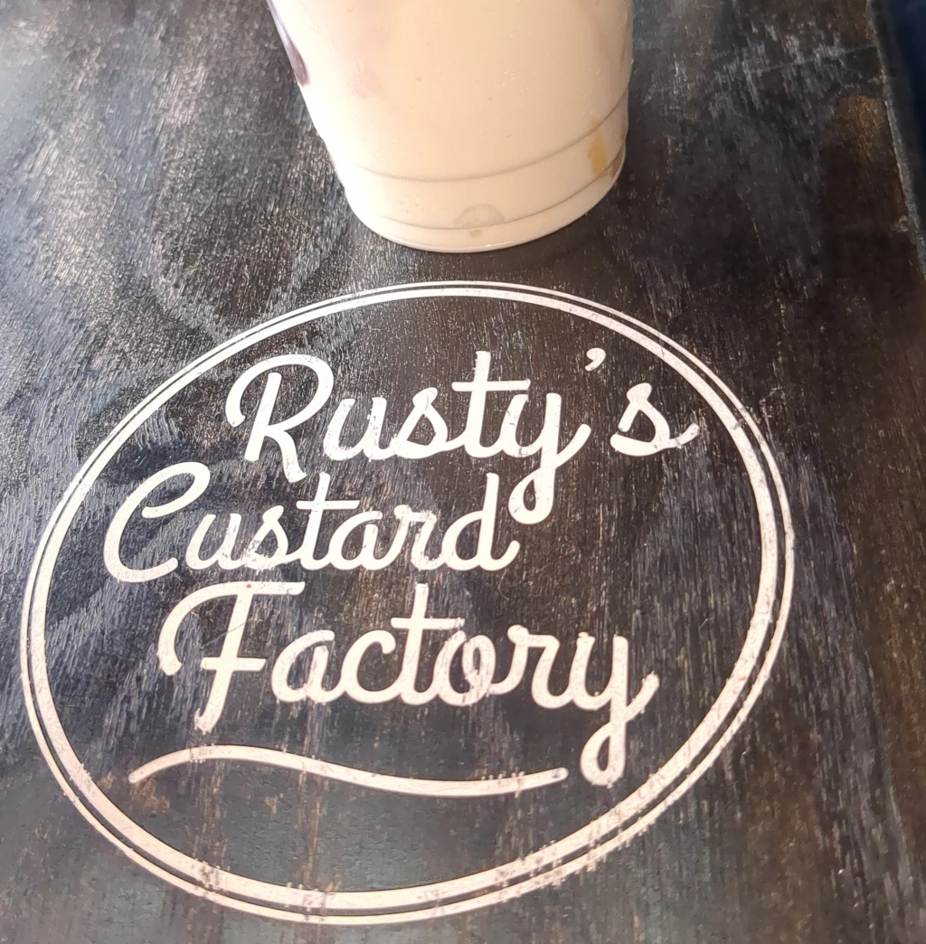 A sign that says 'Rusty's Custard Factory'