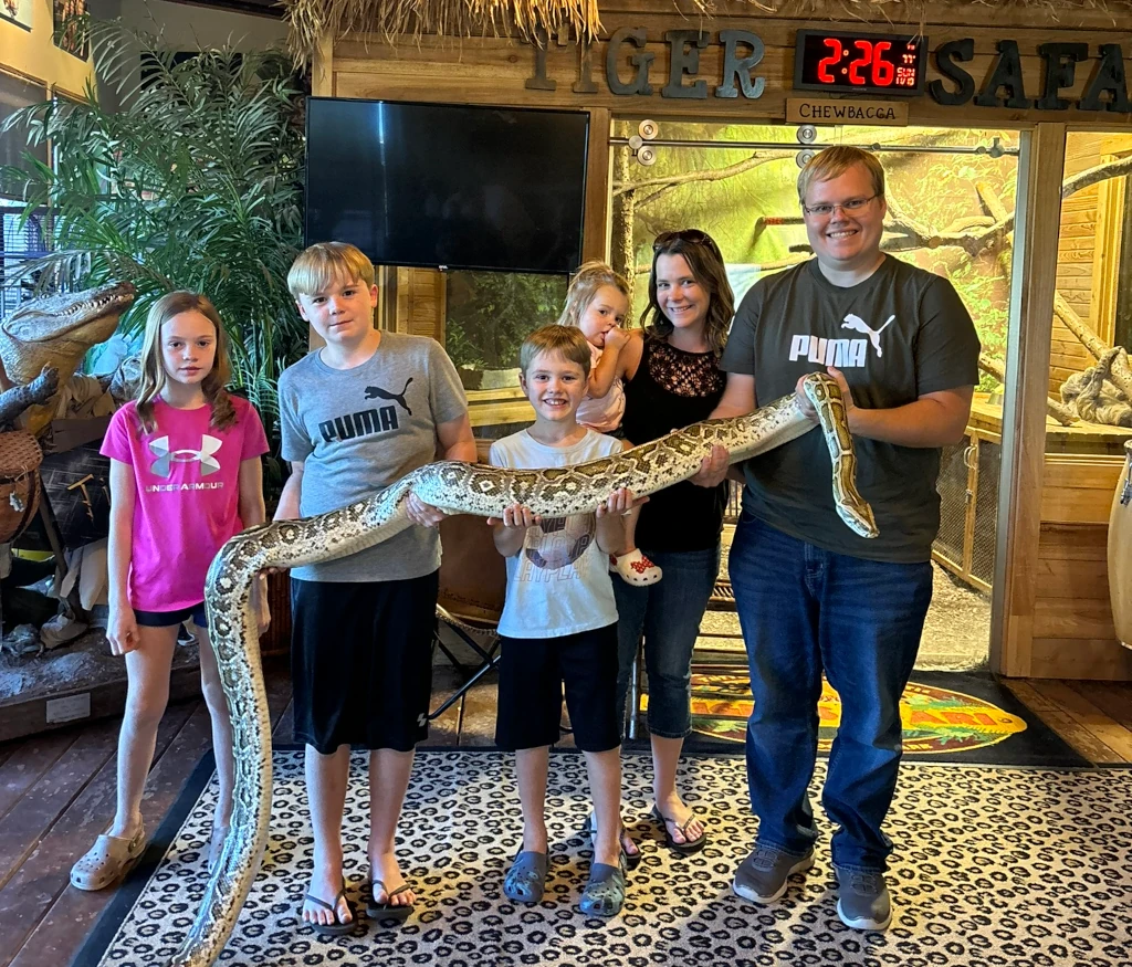 A family holding a large snake