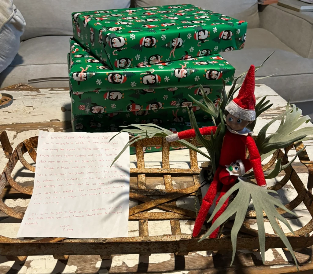 An elf-on-the-shelf doll with some presents