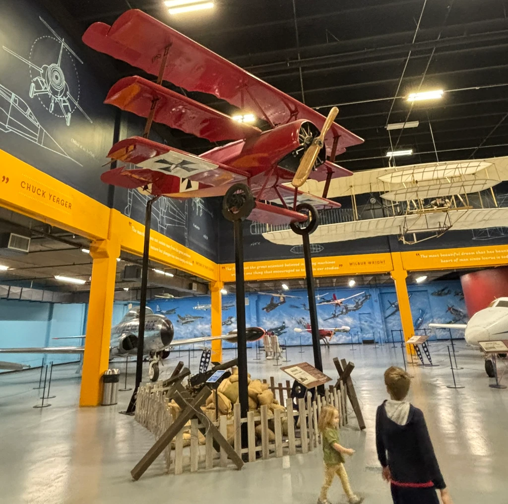 An old propeller airplane suspended from the ceiling