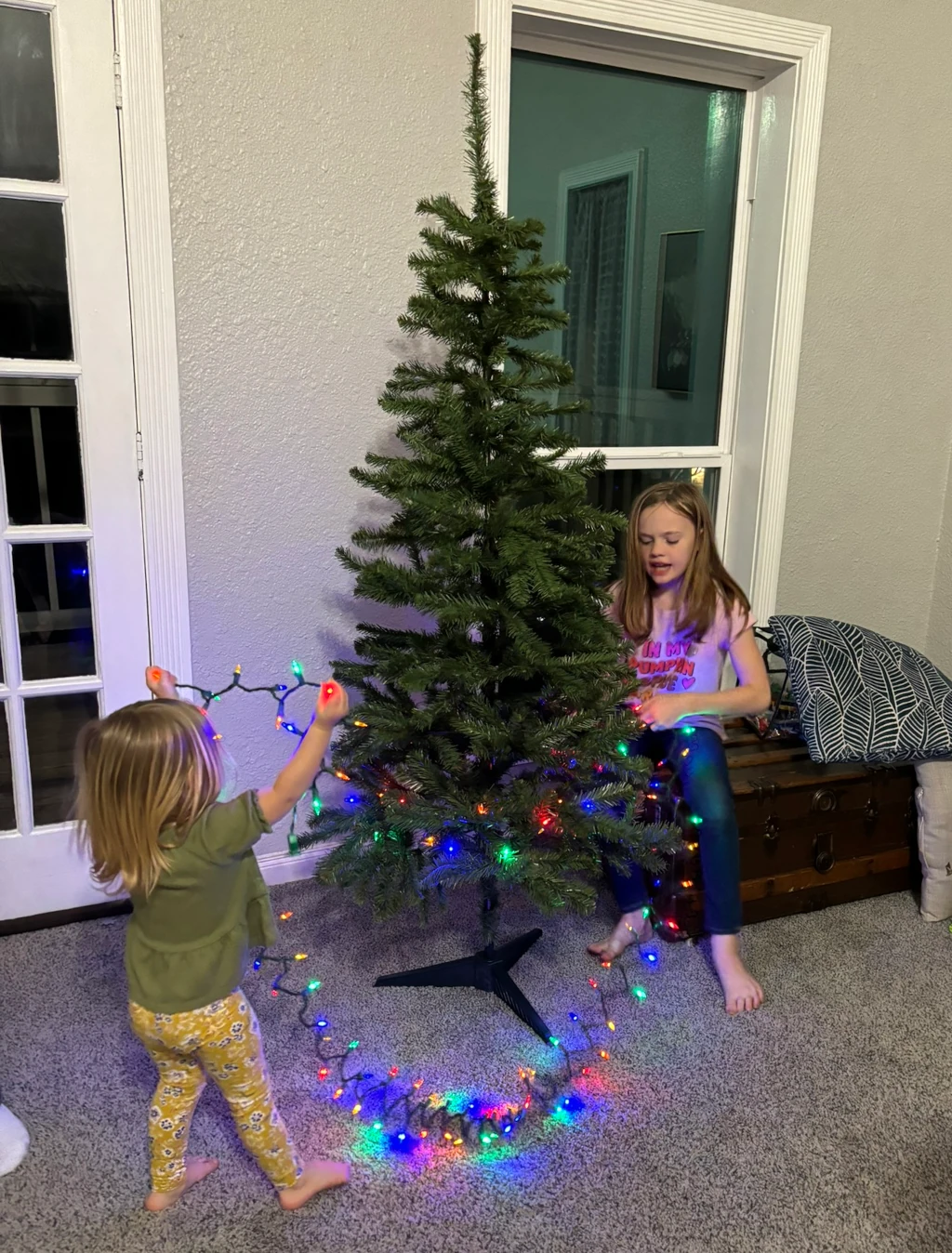 Two girls decorating a Christmas tree