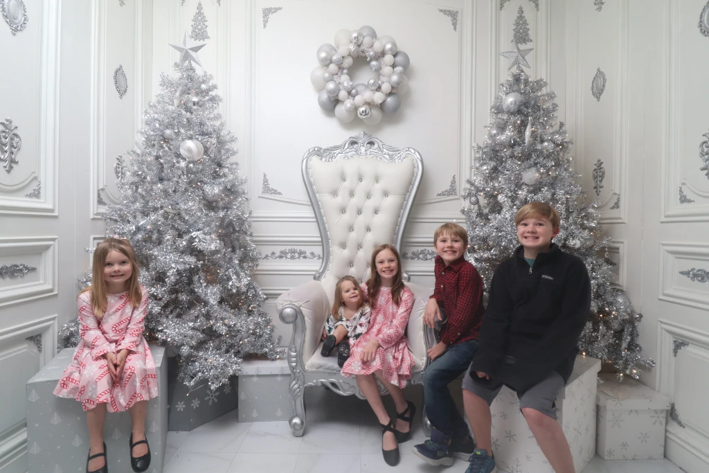 Kids posing by Christmas trees