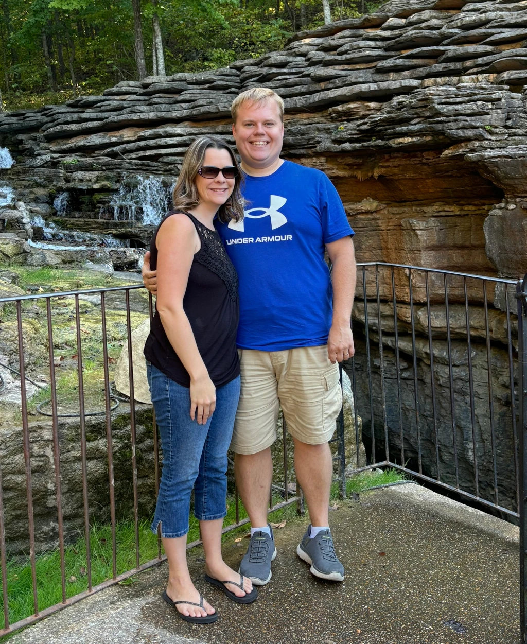 A couple standing in front of a waterfall