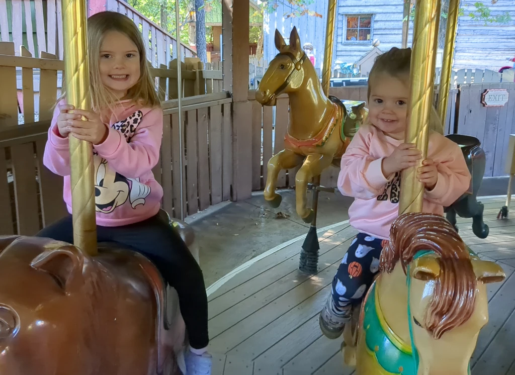 Two girls riding a carousel