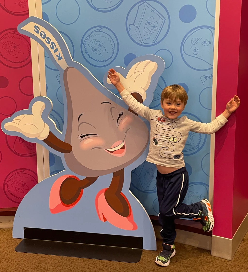 A kid posing with a Hersey Kiss