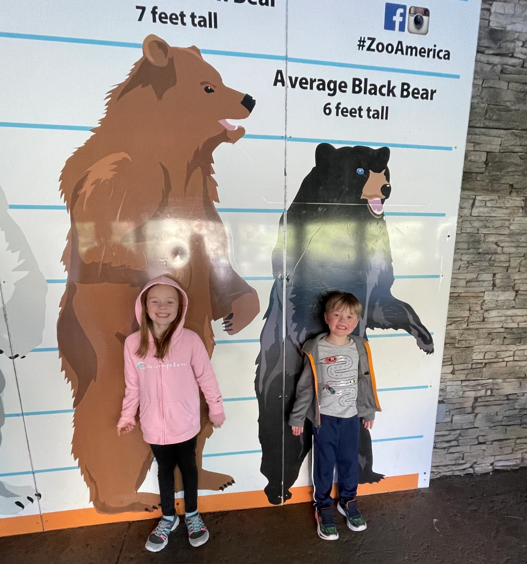 Kids posing by a sign with bears