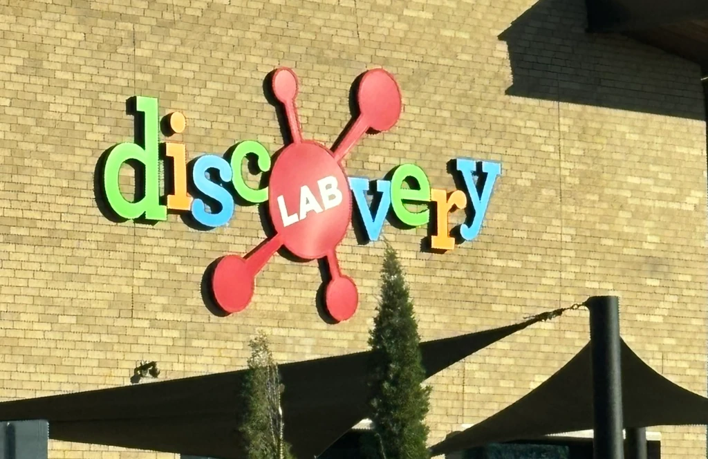 A sign on the side of a building that reads 'Discovery Lab'