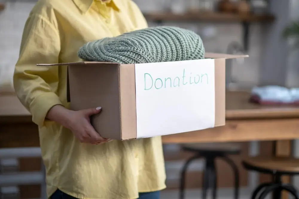 A woman holding a box labeled 'donation'